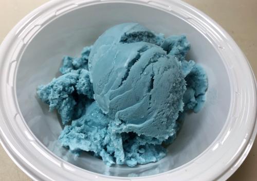 A scoop of blue ice cream in a bowl