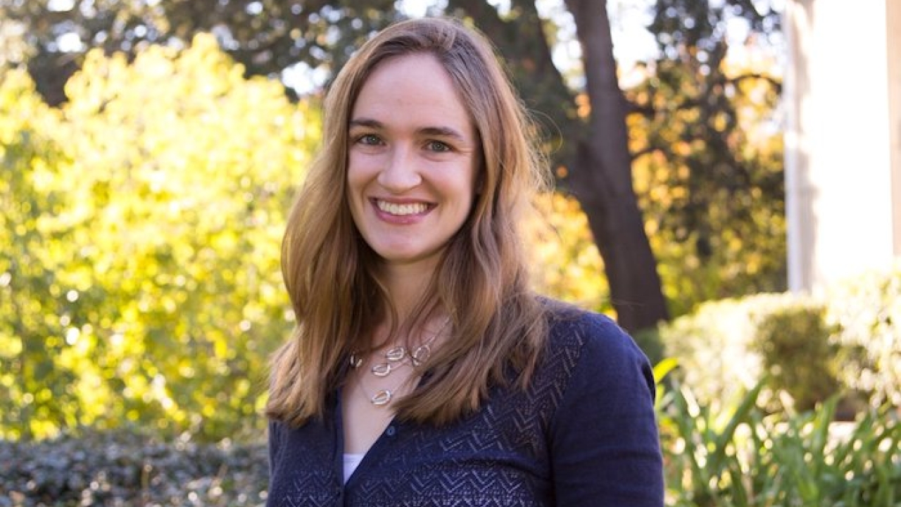 Person standing outside, smiling at camera